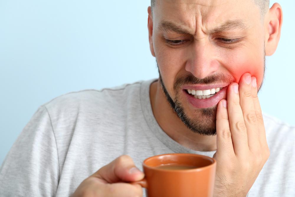 Man With Sensitive Teeth And Cup Of Hot Coffee